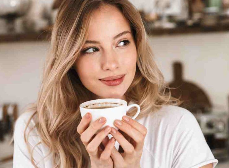 Giovane donna ha tra le mani una tazzina di caffè